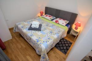 Dormitorio pequeño con cama con edredón y almohadas en Krnic NEW Fiore en Mali Lošinj