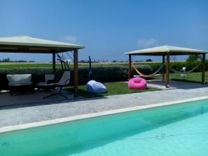 una piscina con 2 columpios y un pabellón en Lavanda Country House, en Pescia Romana