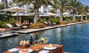 een zwembad in een resort met een tafel met eten en drinken bij Estepona Luxe top appartement in finca de cortesin d38 in Estepona