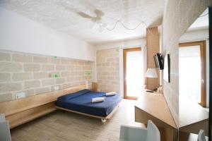 a bedroom with a bed and a tv in a room at Cave Bianche Hotel in Favignana