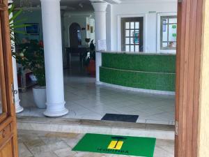 una alfombra de bienvenida en la entrada de un edificio en Jequitiba Hotel Frente ao Mar, en Guarujá