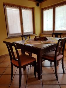 a dining room table with chairs and windows at Casa chanoux in Chambave