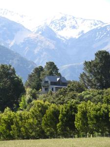 a house on a hill with mountains in the background at Cubby House Stay Kaikoura in Kaikoura