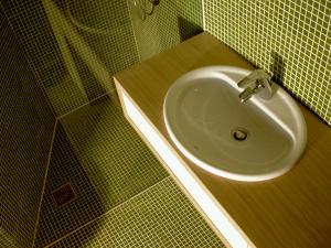 baño con lavabo y pared de azulejos verdes en Architectural City Loft en Sofía