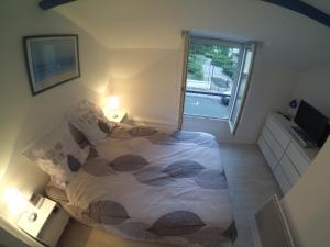 a small bedroom with a bed and a window at Maison de Pêcheurs en centre ville in Deauville