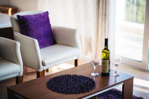 uma garrafa de vinho e dois copos numa mesa em Apartments Hollaj em Ulcinj