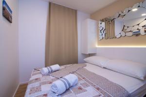a bedroom with a bed with a mirror on the wall at Tomica Apartments with Pool in Biograd na Moru