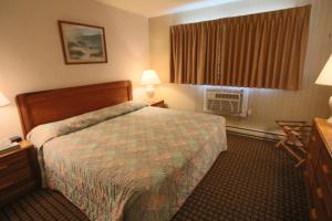 a hotel room with a bed and a window at Colton Court Motor Inn in Cape May