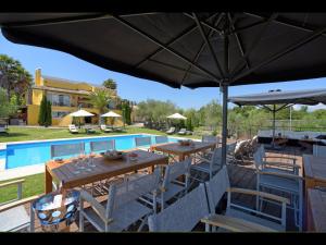 un patio con tavoli, sedie e piscina di Villa Privilege Classic & Exclusive a Gouviá