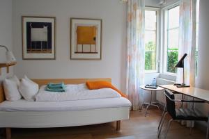 una camera da letto con un letto, una scrivania e una finestra di Hotell Oskar a Lund