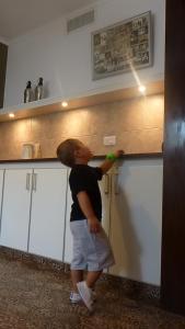 a young boy is standing in a kitchen at Casa con garage y patio - 6 personas - 26 y 45 in La Plata