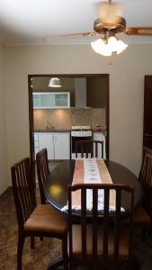 a dining room table with chairs and a kitchen at Casa con garage y patio - 6 personas - 26 y 45 in La Plata +12 photos