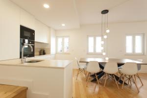 リスボンにあるMouraria Blue Three-Bedroom Apartment w/ Parking - by LU Holidaysの白いキッチン(テーブル、椅子付)