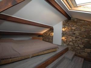 a bedroom with a bed and a stone wall at Maison Vauban Plus in Saint-Raphaël