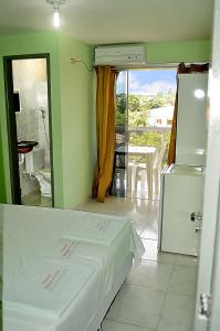a room with a bed and a view of a kitchen at Pousada Refúgio do Forte in Itamaracá