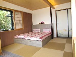 a bedroom with a bed and a large window at KyuFun Komachi in Jiufen