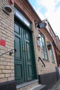 a green door on the side of a brick building at Hotell Oskar in Lund