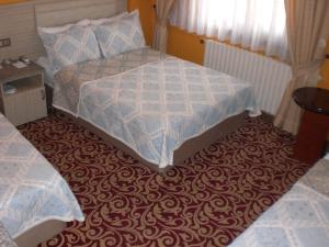 a small bedroom with a bed and a carpet at Grand Reis Hotel in Istanbul