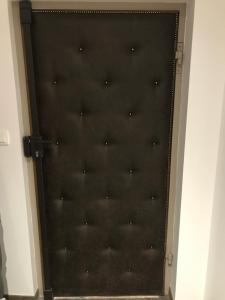 Czarne drzwi ze srebrnymi kropkami w obiekcie Le Vieux Troyes w Troyes