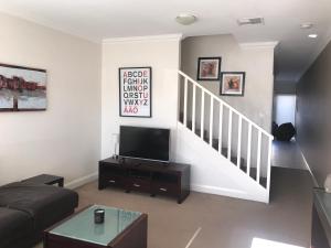 a living room with a couch and a tv at Travers Street Apartment in Wagga Wagga