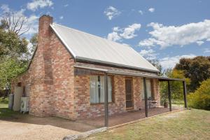 a brick house with a metal roof at Grampians Pioneer Cottages in Halls Gap