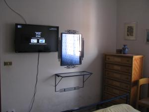 a room with a television on the wall with a dresser at Appartamento Centrale in Scalea