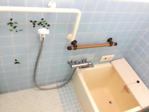 ein Badezimmer mit einer Badewanne und einem Waschbecken in der Unterkunft Guesthouse Kyoto Kaikonoyashiro in Kyoto