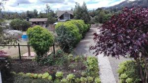 un jardín con arbustos y flores frente a una casa en Finca Saron Hostería & Spa, en Sogamoso