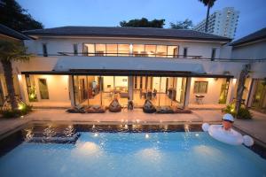 a large swimming pool in front of a house at Villa Navin in Jomtien Beach