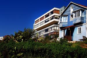 un immeuble d'appartements avec un bâtiment bleu et blanc dans l'établissement Departamento Cerro Alegre 113, à Valparaíso