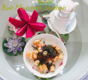 un plato blanco con un tazón de comida en una mesa en Binh Minh Hotel, en Ninh Binh