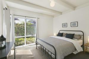a bedroom with a bed and a large window at Mysa Anglesea Sleeps 7 WiFi SmartTV Cafes Shops in Anglesea