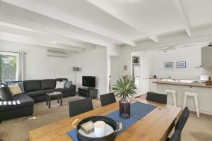 a living room with a couch and a table at Mysa Anglesea Sleeps 7 WiFi SmartTV Cafes Shops in Anglesea