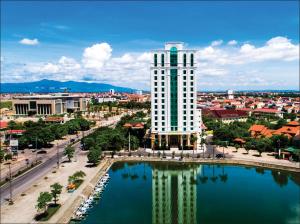 un edificio alto con un reflejo en el agua en Royal Quang Binh Hotel, en Dong Hoi