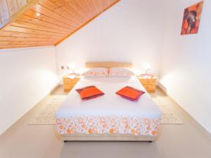 a bedroom with a bed with two pillows on it at Villa Raljević in Stanići