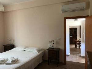 1 dormitorio con 1 cama y 1 mesa con lámpara en Villa del Nespolo, en Fiumefreddo di Sicilia