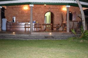 a patio with tables and chairs in a brick building at Marian Holiday Bungalow in Puttalam