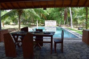 a table and chairs in front of a swimming pool at Marian Holiday Bungalow in Puttalam