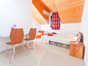 a bedroom with a bed and a table and chairs at Villa Raljević in Stanići