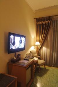 um quarto de hotel com uma televisão de ecrã plano na parede em Sarasvati Borobudur em Borobudur