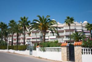 a large building with palm trees in front of a street at Apartment Martinez Casablanca in Alcossebre