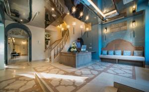 a lobby with a person sitting at a desk with a laptop at Relais Le Chevalier in Riga