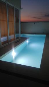 a large swimming pool with lights in a room at St. Peter's Pool Holiday Apartment in Marsaxlokk