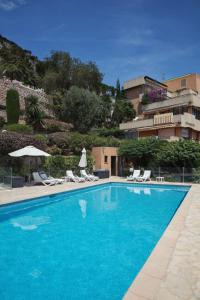 a swimming pool with chairs and a building at Monaco Country Park in Roquebrune-Cap-Martin