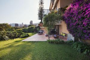 einen Garten mit lila Blumen an der Seite eines Hauses in der Unterkunft Monaco Country Park in Roquebrune-Cap-Martin