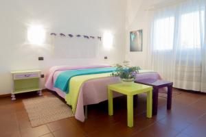 ein Schlafzimmer mit einem Bett und einem Tisch mit Blumen darauf in der Unterkunft B&B Salighes in Ozieri