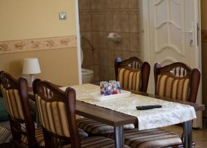 uma mesa de jantar com 4 cadeiras e uma mesa com em Bencsik Tanya Szentkirály - Szálláshely & Rendezvényház em Szentkirály
