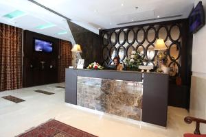 een vrouw bij de receptie in een hotellobby bij The Eclipse Boutique Suites in Abu Dhabi