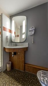 a bathroom with a sink and a mirror at Hôtel The Originals City Le Berry - proche centre-ville - Gare in Bourges