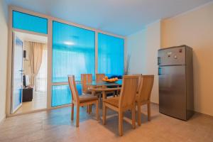 a dining room with a table and a refrigerator at Amon Ra Hotel in Sozopol